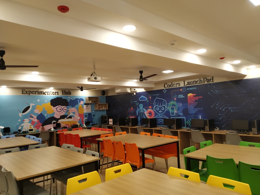 Colourful innovation lab classroom with orange and yellow chairs