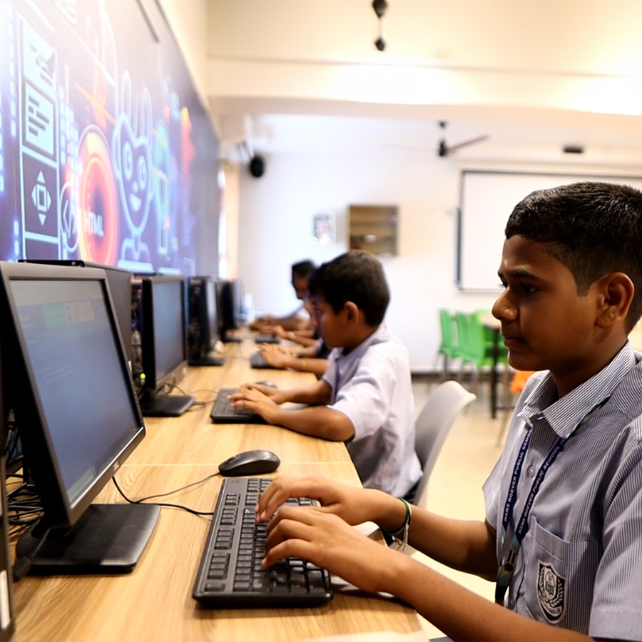 Students typing at a row of computers in the lab
