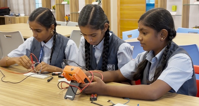 Student assembling an orange electronic project